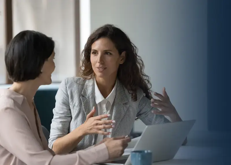 two business women discussing how to send gift cards online.