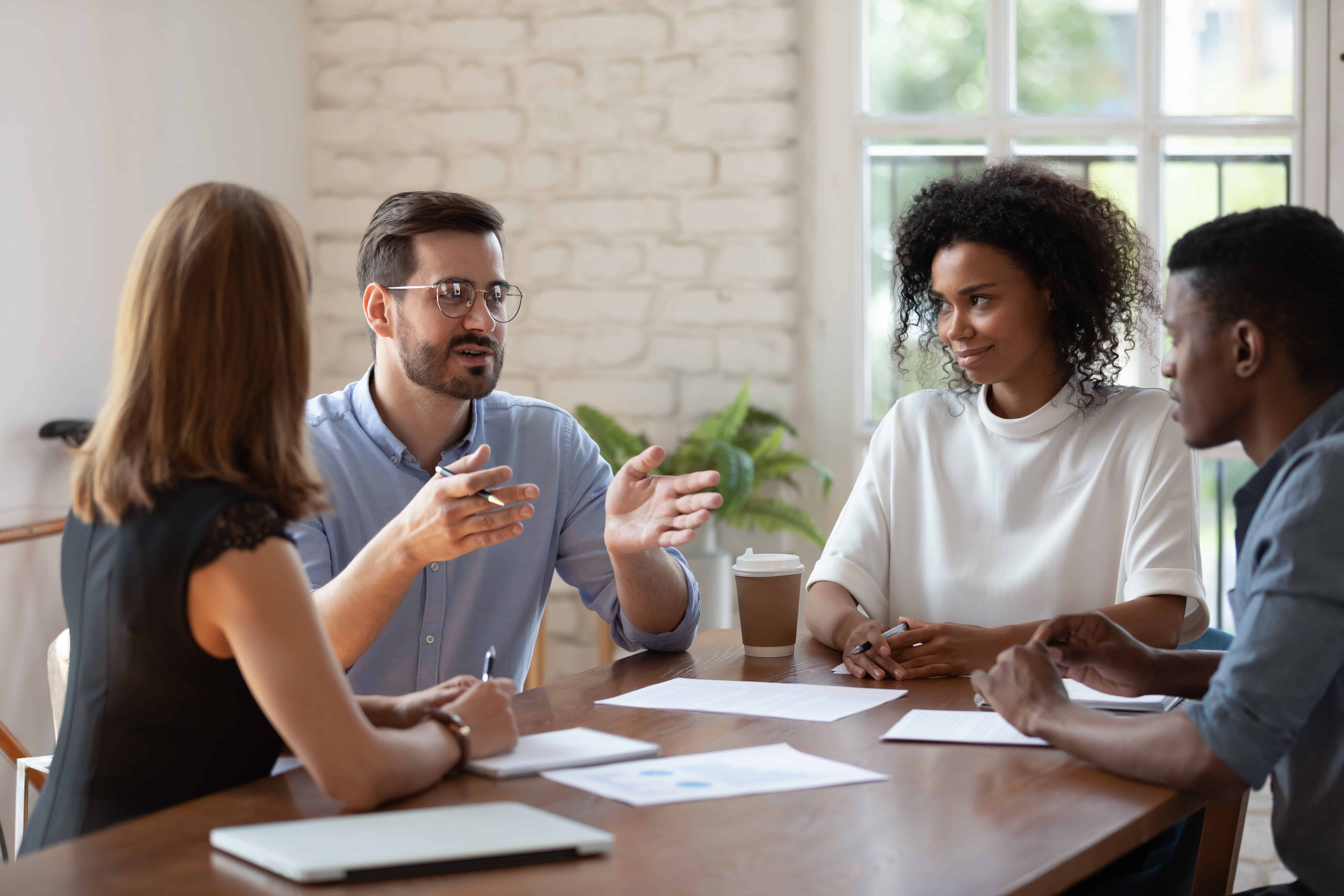 Employees discussing workplace gamification strategies to secure digital reward prizes.