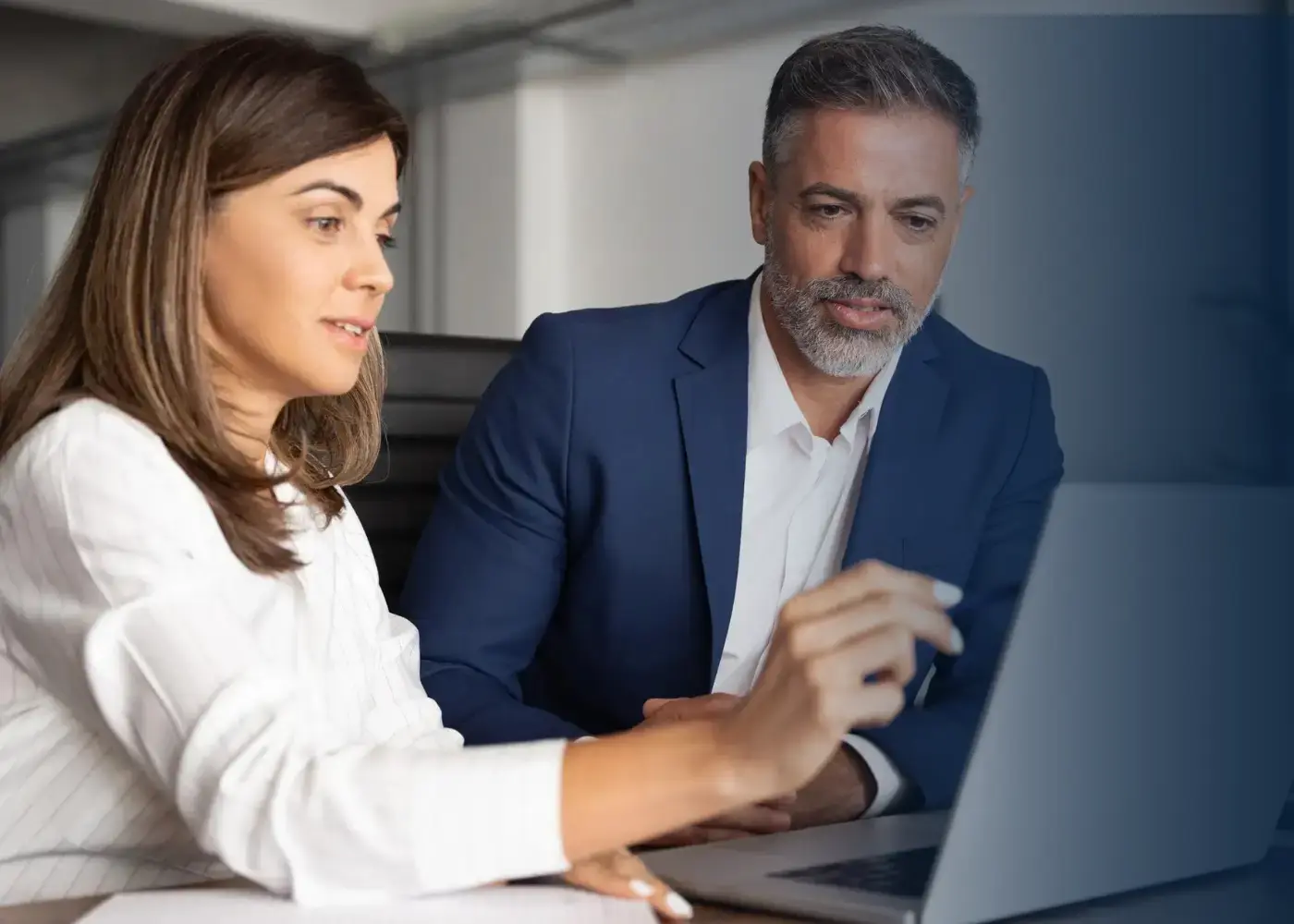 Two incentive specialists sharing a laptop to work