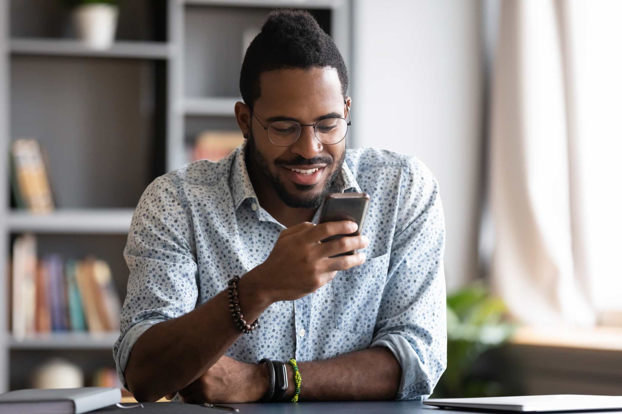 man in home office receiving gift card via text