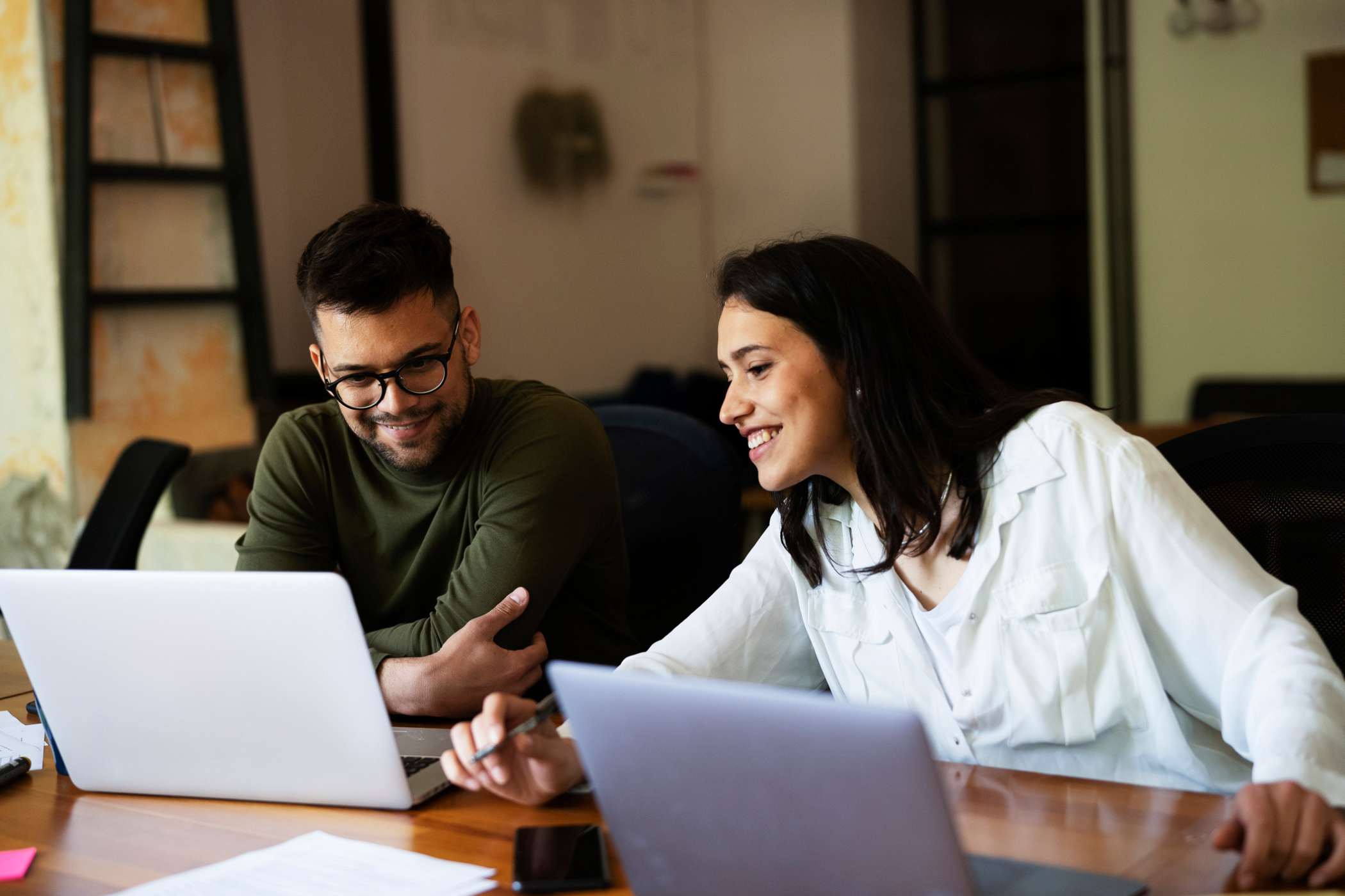 two students sitting at their laptops at home